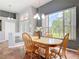 Dining room showcasing a wooden dining set and large window offering a pleasant view of the tropical landscape at 1860 Forough Cir, Port Orange, FL 32128