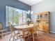 Dining area with natural light, featuring a wooden table set, matching hutch, and views to a tropical landscaped yard at 1860 Forough Cir, Port Orange, FL 32128
