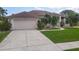 Spacious home with a well-maintained lawn, a two-car garage, and beautiful landscaping at 1860 Forough Cir, Port Orange, FL 32128