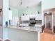Bright kitchen features granite countertops, white cabinets, and views to the hallway and other living spaces at 1860 Forough Cir, Port Orange, FL 32128