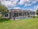 Backyard view of the screened pool and patio area, perfect for outdoor living at 1860 Forough Cir, Port Orange, FL 32128