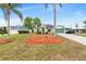 Charming single Gathering home with a green lawn, mulch, palm trees, and driveway leading to the garage at 1862 Shelby Ter, Deltona, FL 32725
