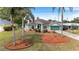 Landscaped front exterior with mulch beds and palm trees with a long driveway at 1862 Shelby Ter, Deltona, FL 32725