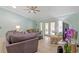 Inviting living room featuring a plush sofa, ceiling fan, and sliding glass doors to the patio at 1862 Shelby Ter, Deltona, FL 32725