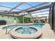 Backyard pool and jacuzzi is covered with a screen and has covered furniture at 1862 Shelby Ter, Deltona, FL 32725