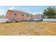 Backyard featuring an in-ground pool, patio, fencing, and a two-story pink house at 193 Fish Hawk Dr, Winter Haven, FL 33884