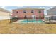 Backyard with an in-ground pool, patio, fencing, and a two-story home at 193 Fish Hawk Dr, Winter Haven, FL 33884