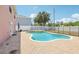 View of the pool and surrounding brick patio, with a safety fence and the exterior of the house at 193 Fish Hawk Dr, Winter Haven, FL 33884