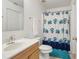 Bright bathroom featuring vanity, toilet, and shower with blue floral curtain at 193 Fish Hawk Dr, Winter Haven, FL 33884