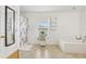Bright bathroom featuring a soaking tub, tiled floors, and floral shower curtain at 193 Fish Hawk Dr, Winter Haven, FL 33884