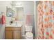 Cozy bathroom featuring a wooden vanity, decorative floral shower curtain, and neutral tile flooring at 193 Fish Hawk Dr, Winter Haven, FL 33884