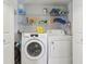 Convenient laundry room featuring a washer, dryer, and shelving at 193 Fish Hawk Dr, Winter Haven, FL 33884