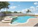 The backyard shows a pristine pool and spa combo, framed by a brick patio and a secure safety fence at 193 Fish Hawk Dr, Winter Haven, FL 33884
