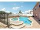 The backyard features a fenced in pool and spa surrounded by lush greenery and a brick patio at 193 Fish Hawk Dr, Winter Haven, FL 33884