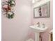Stylish powder room with a pedestal sink and decorative butterfly wall art, adds charm to the home at 193 Fish Hawk Dr, Winter Haven, FL 33884