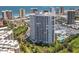 Beautiful aerial view of a white beachfront condo building with balconies, set amidst green lawns and swaying palm trees at 2 Oceans West Blvd # 1007, Daytona Beach, FL 32118