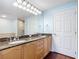 Bathroom featuring dual sinks, granite countertops, and a large mirror with Hollywood lighting at 2 Oceans West Blvd # 1007, Daytona Beach, FL 32118