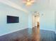 Spacious bedroom featuring a flat screen tv, hardwood floors and an attached bath at 2 Oceans West Blvd # 1007, Daytona Beach, FL 32118