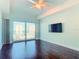 Bedroom featuring a flat screen tv, ceiling fan, hardwood floors and a balcony with ocean views at 2 Oceans West Blvd # 1007, Daytona Beach, FL 32118