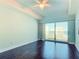 Bright bedroom with a ceiling fan, hardwood floors, and a balcony with amazing ocean views at 2 Oceans West Blvd # 1007, Daytona Beach, FL 32118