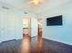 Light-filled bedroom with hardwood floors, ceiling fan, and doors leading to the bathroom and kitchen at 2 Oceans West Blvd # 1007, Daytona Beach, FL 32118