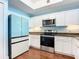 Modern kitchen featuring stainless steel appliances, granite countertops, and white cabinetry at 2 Oceans West Blvd # 1007, Daytona Beach, FL 32118