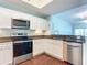 A well-lit kitchen with white cabinets, granite countertops, and modern stainless steel appliances at 2 Oceans West Blvd # 1007, Daytona Beach, FL 32118
