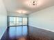 Spacious living room with hardwood floors, modern lighting and sliding glass doors to a balcony at 2 Oceans West Blvd # 1007, Daytona Beach, FL 32118