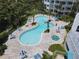 Aerial view of a resort-style pool featuring palm trees, umbrellas, lounge chairs and pristine blue waters at 2 Oceans West Blvd # 1007, Daytona Beach, FL 32118