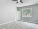 Bright bedroom with light gray walls, tile flooring, a ceiling fan, and a sunlit window at 200 S Montgomery Ave, Deland, FL 32720