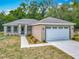 Attractive single-story house showcases a gray roof, stone accents, and a driveway leading to an attached garage at 200 S Montgomery Ave, Deland, FL 32720