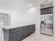 Bright open kitchen features a large island, stainless steel fridge, and gray cabinets at 200 S Montgomery Ave, Deland, FL 32720