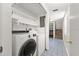 Functional laundry room with modern washer and dryer units and shelving at 207 Pine Cone Trl, Ormond Beach, FL 32174