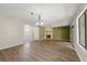 Spacious living room boasts hardwood floors, a stone fireplace, and large windows with ample natural light at 207 Pine Cone Trl, Ormond Beach, FL 32174