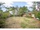 View of the open backyard with lush landscaping, trees and the rear of the home at 2126 Sabal Palm Dr, Edgewater, FL 32141