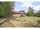 A view of the backyard featuring a fire pit, and the house with mature trees at 2126 Sabal Palm Dr, Edgewater, FL 32141