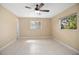 Cozy bedroom with a ceiling fan, tile flooring, and two windows offering natural light at 2126 Sabal Palm Dr, Edgewater, FL 32141
