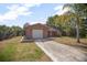 Charming brick home with attached garage, screened in porch, and a concrete driveway at 2126 Sabal Palm Dr, Edgewater, FL 32141