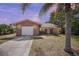 Charming brick home featuring a one-car garage, concrete driveway, and tropical landscaping at 2126 Sabal Palm Dr, Edgewater, FL 32141