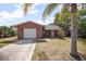 Charming brick home featuring a one-car garage, concrete driveway, and tropical landscaping at 2126 Sabal Palm Dr, Edgewater, FL 32141