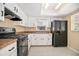 Charming kitchen with white cabinetry, tile floors, and black appliances at 2126 Sabal Palm Dr, Edgewater, FL 32141