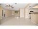 Open concept living area with tile floors, neutral walls, ceiling fan, and kitchen bar at 2126 Sabal Palm Dr, Edgewater, FL 32141
