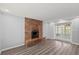 Bright living room features a brick fireplace, wood floors and access to the patio at 2144 Brian Ave, South Daytona, FL 32119