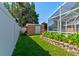 Backyard space featuring a shed with greenery along a white fence at 2213 Needle Palm Dr, Edgewater, FL 32141