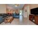 Spacious living room with tile flooring, comfortable seating, and a view of the adjacent dining area at 2213 Needle Palm Dr, Edgewater, FL 32141