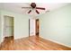 Bedroom with wood floors, ceiling fan, and open doors to bathroom at 2214 Danforth Ave, Deltona, FL 32738
