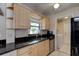 Kitchen with granite counters, stainless appliances, and adjacent laundry area at 2214 Danforth Ave, Deltona, FL 32738