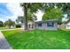 Beautiful one-story home boasting lush green lawn, mature shade trees, attached garage, and inviting front porch at 2254 Green St, South Daytona, FL 32119