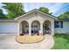 Close-up of the front porch with decorative seating, potted plants, and arched entryways for a welcoming curb appeal at 2254 Green St, South Daytona, FL 32119