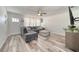 Bright living room featuring modern gray sofa, light wood floors, ceiling fan and natural light from large window at 2254 Green St, South Daytona, FL 32119